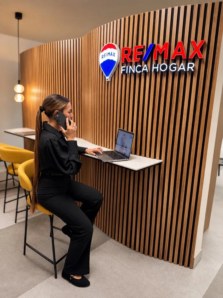 Eva Méndez en su oficina RE/MAX Finca Hogar Zaragoza, atendiendo consultas inmobiliarias